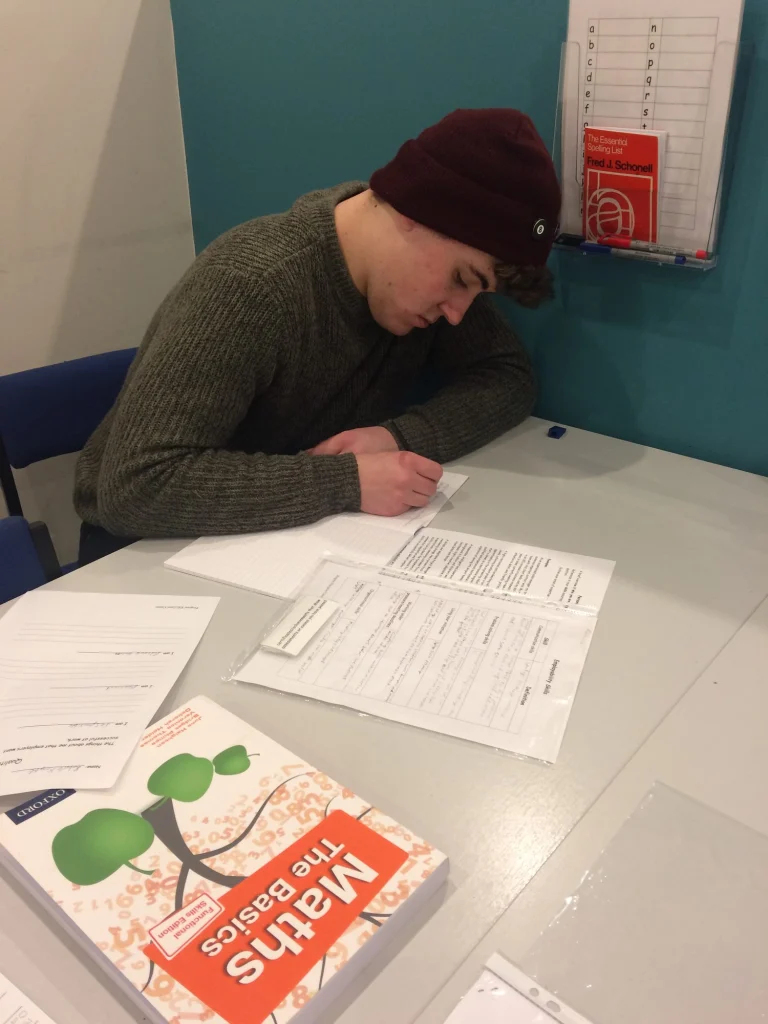 Adult learner working on Maths The Basics worksheets