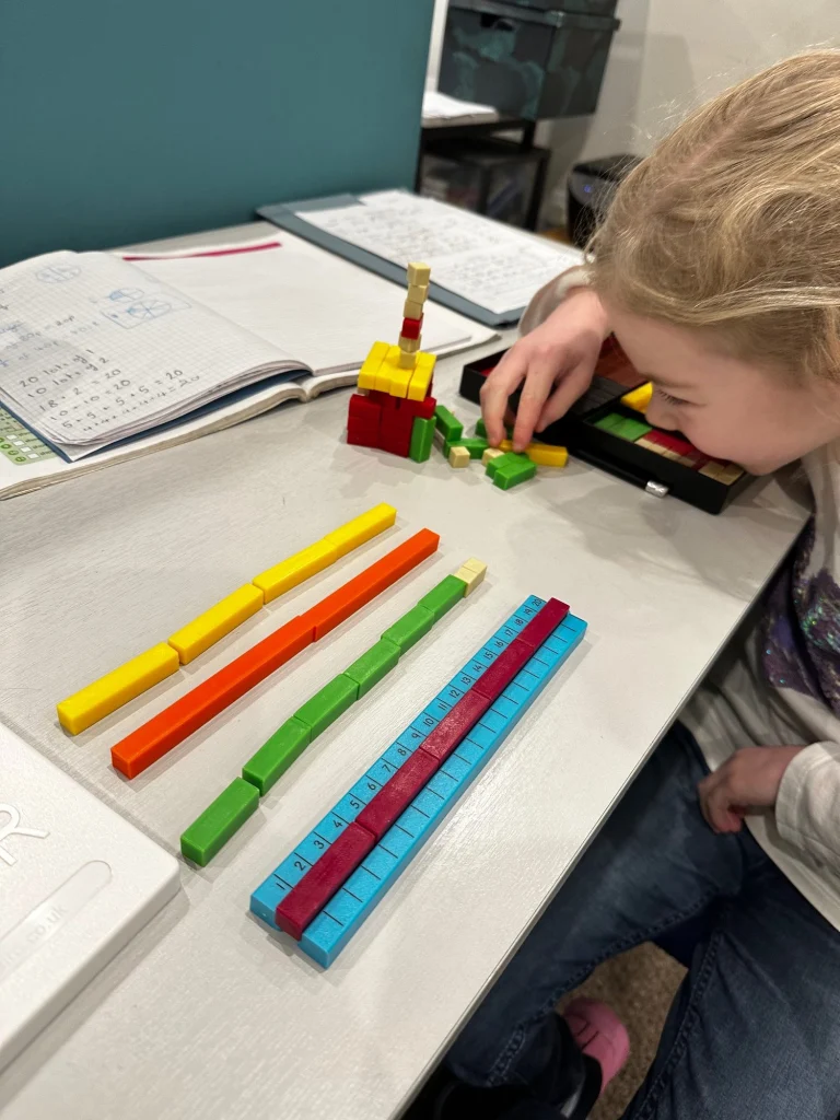 Young pupil building number bonds to 20 with coloured rods