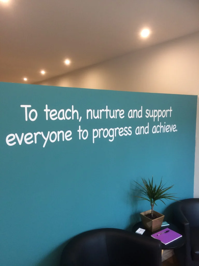 Centre wall painted with the mission statement: To teach, nurture and support everyone to progress and achieve.