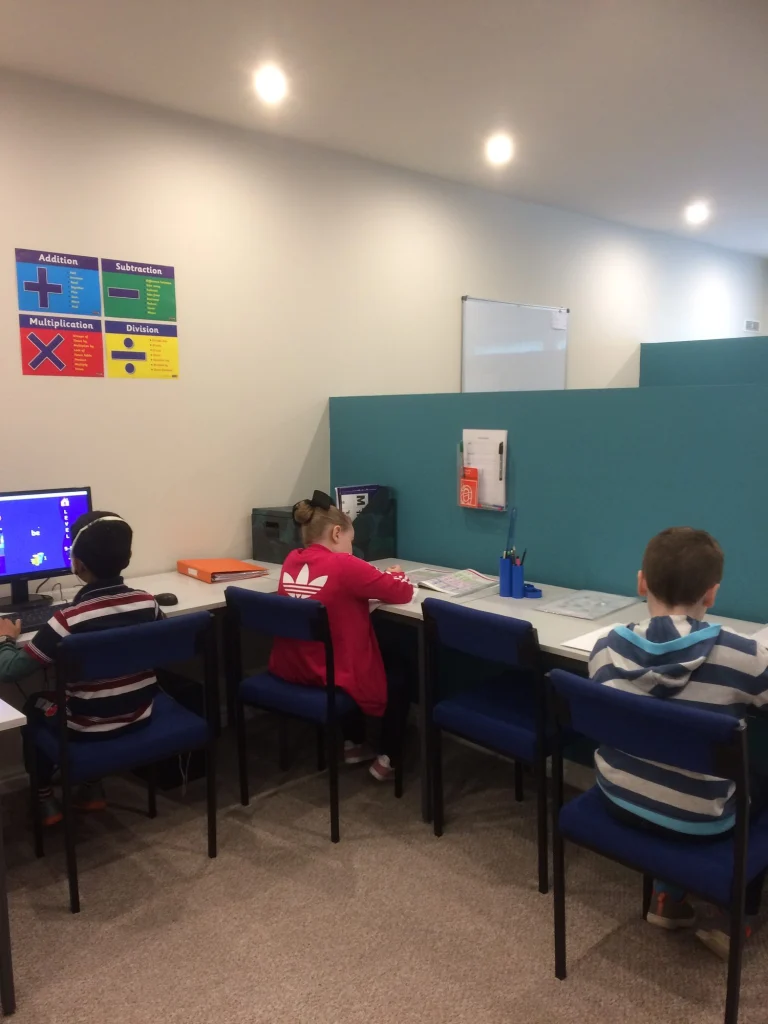 Pupils working at computers and desks in the Darwen centre classroom