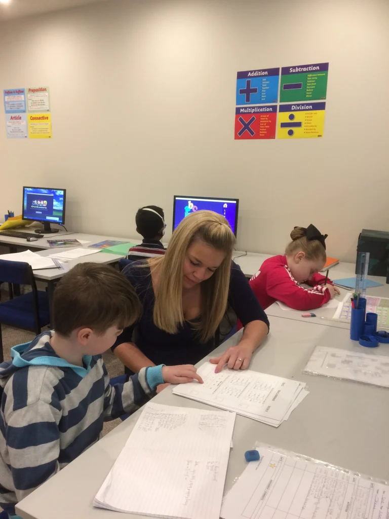 Tutor working with young pupils at desks in the Darwen centre