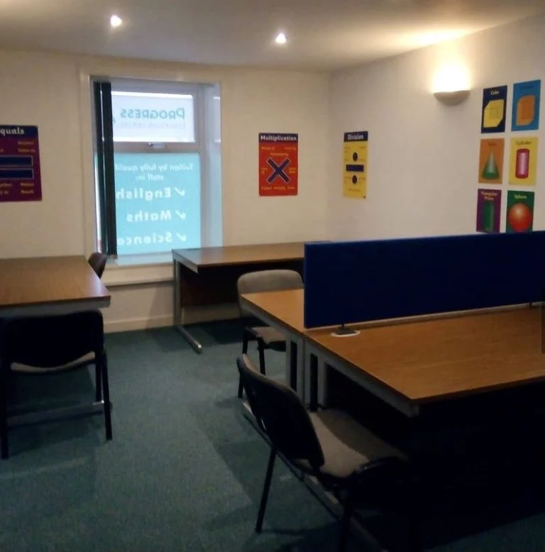 Haslingden centre classroom with desks and a window showing the Progress sign